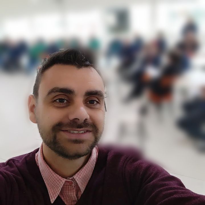 Guilherme Almeida em uma palestra, com o público ao fundo